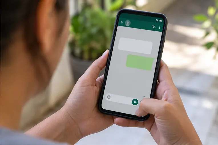 Pessoa usa o celular para enviar mensagem e solicitar orientação sobre coleta de itens volumosos.