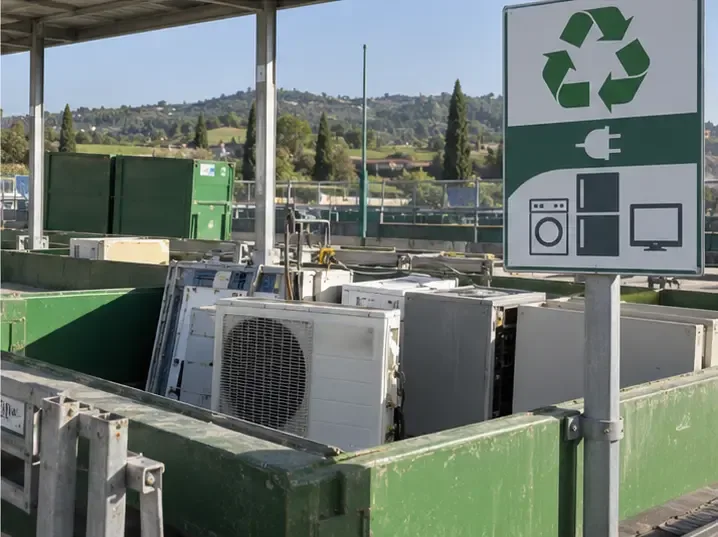 Area di un Ecocentro con contenitori per apparecchiature elettriche ed elettroniche e unità esterne di climatizzatori