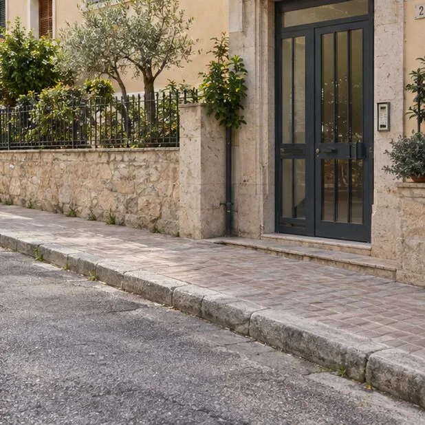 Un marciapiede pulito davanti a un ingresso condominiale dopo la rimozione del divano
