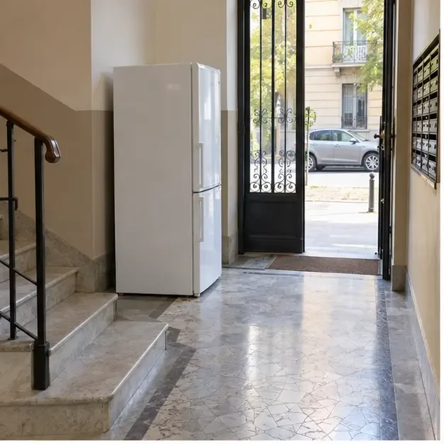 Frigorifero posizionato vicino all’ingresso di un palazzo, con il percorso verso la strada libero