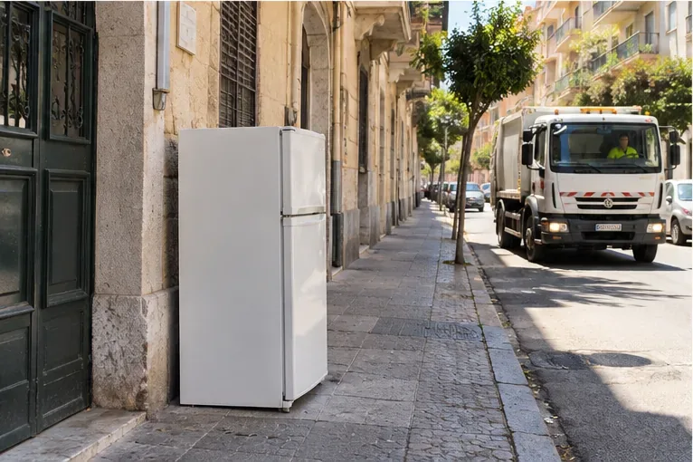 Un frigorifero collocato al piano stradale accanto a un edificio, in attesa del ritiro concordato