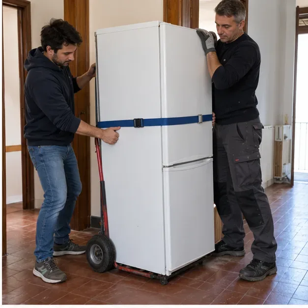 Due persone assicurano un frigorifero verticale con una cinghia su un carrello per elettrodomestici all’interno di una casa.