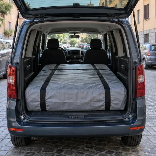 Materasso coperto e fissato con cinghie nel vano posteriore di un veicolo su una strada residenziale