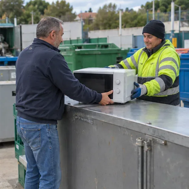 Addetto di un centro di raccolta che riceve un forno a microonde