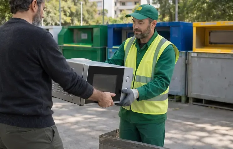 Un cittadino consegna un microonde a un addetto in un’area comunale di raccolta differenziata