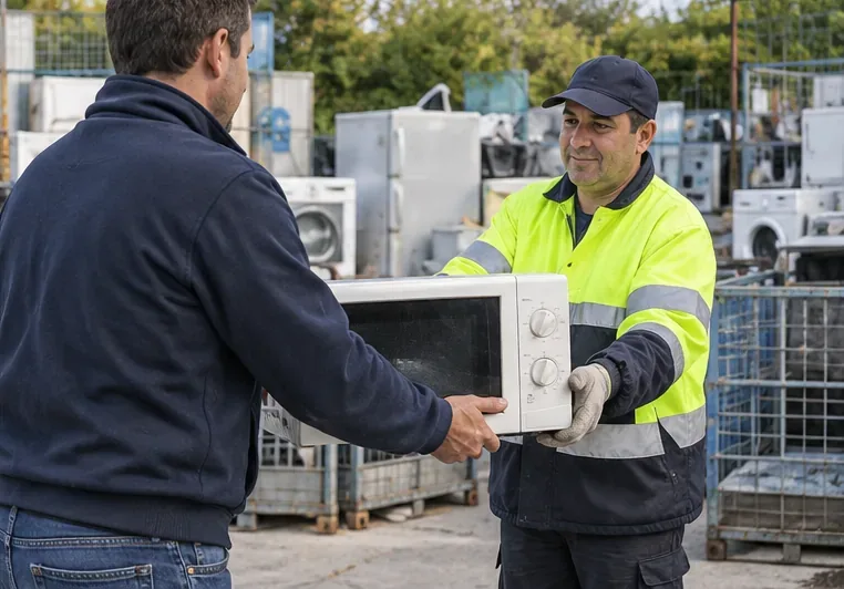 Cittadino che consegna un forno a microonde a un operatore in un centro di raccolta con elettrodomestici sullo sfondo