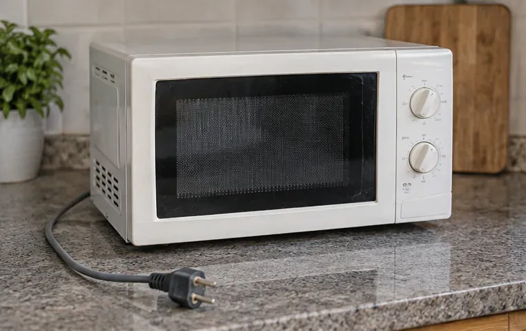 Forno a microonde scollegato dalla presa, con il cavo e la spina visibili sul piano della cucina