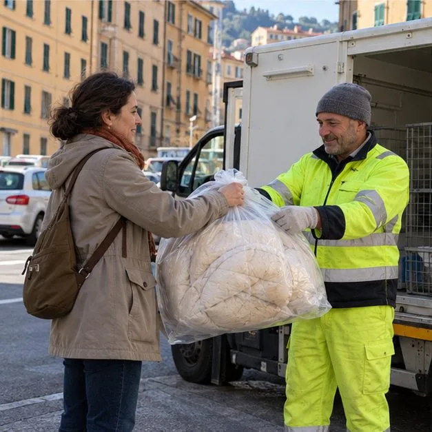 Una cittadina consegna un sacco chiuso con un piumone a un operatore vicino a un furgone di raccolta