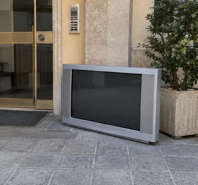 Un televisore voluminoso preparato vicino all'ingresso di un edificio in attesa di un ritiro concordato