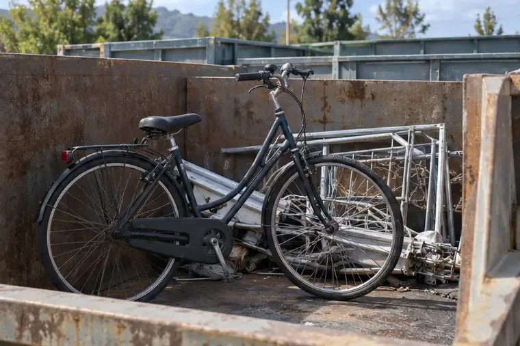 Bicicletta collocata in un contenitore per materiali metallici e ingombranti all’interno di un punto di raccolta.