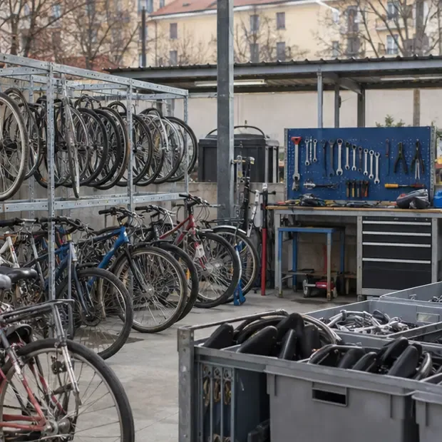 Area ordinata di un laboratorio di riuso con biciclette appese, pezzi separati e attrezzi per la riparazione
