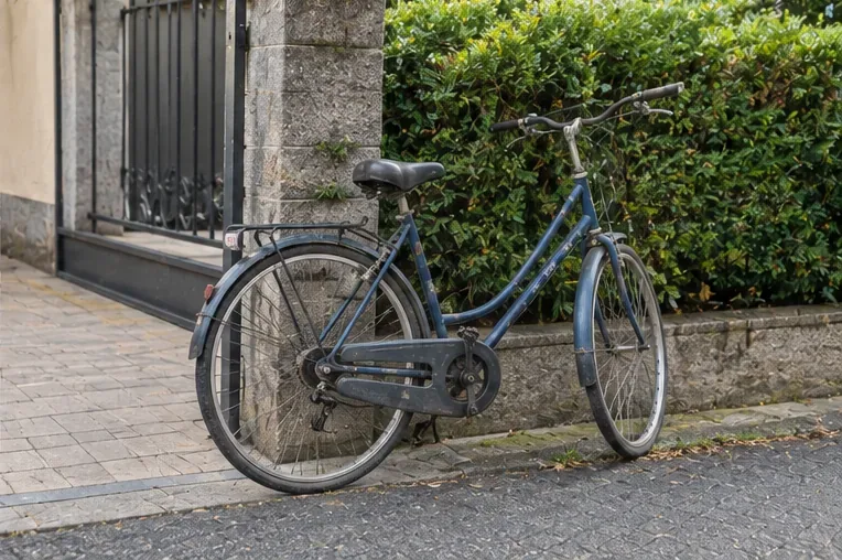 Una bicicletta usata parcheggiata ordinatamente vicino al bordo strada in attesa di gestione