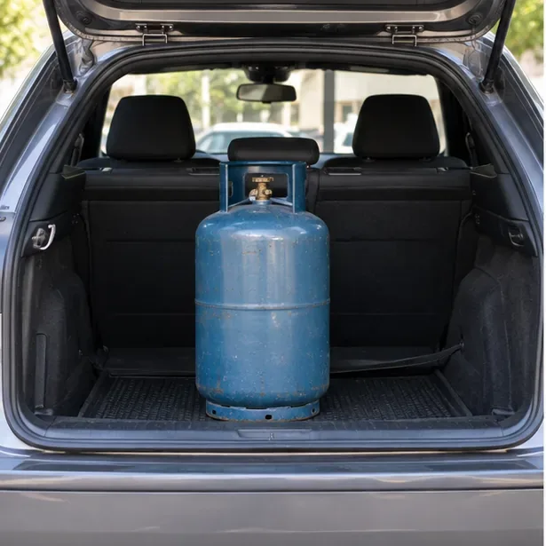 Bombola del gas in posizione verticale nel vano di carico di un’automobile prima di essere fissata per il trasporto.