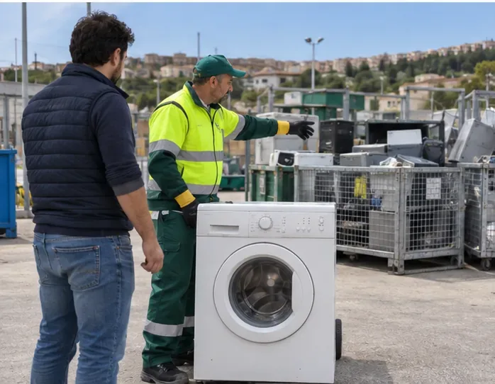 Un addetto in abbigliamento ad alta visibilità indica dove conferire una lavatrice in un centro di raccolta RAEE