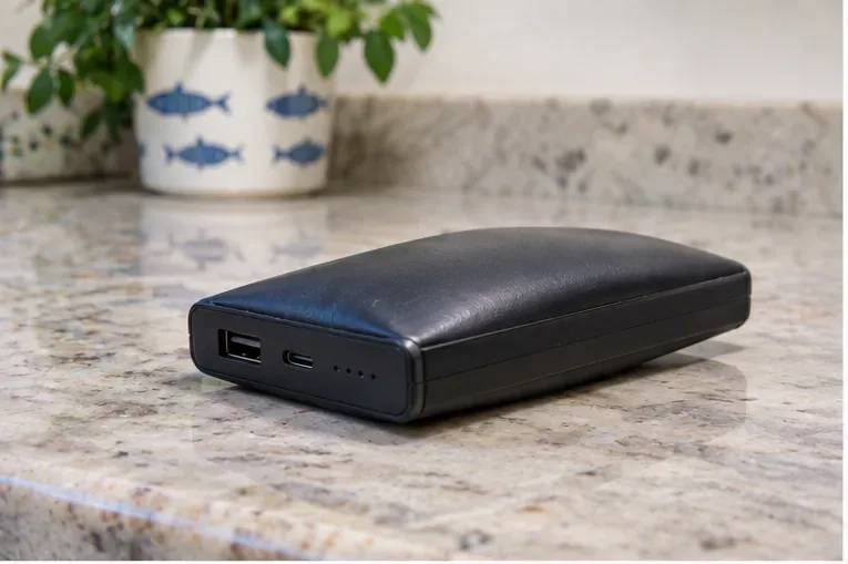 Power bank visibilmente gonfia appoggiata su un piano stabile, senza cavi collegati