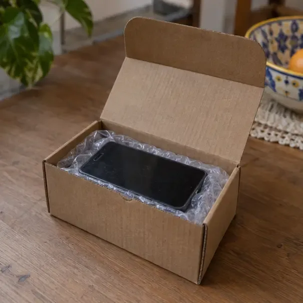 Uno smartphone spento è protetto in una piccola scatola di cartone prima del conferimento