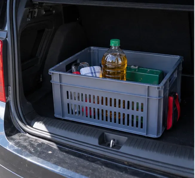 Une bouteille fermée contenant de l’huile de cuisson usagée est maintenue debout dans une caisse placée dans le coffre d’une voiture.