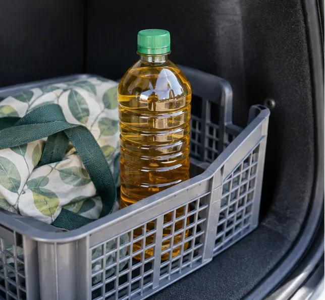 Bouteille fermée contenant de l'huile de cuisson usagée placée debout dans une caisse pour le transport