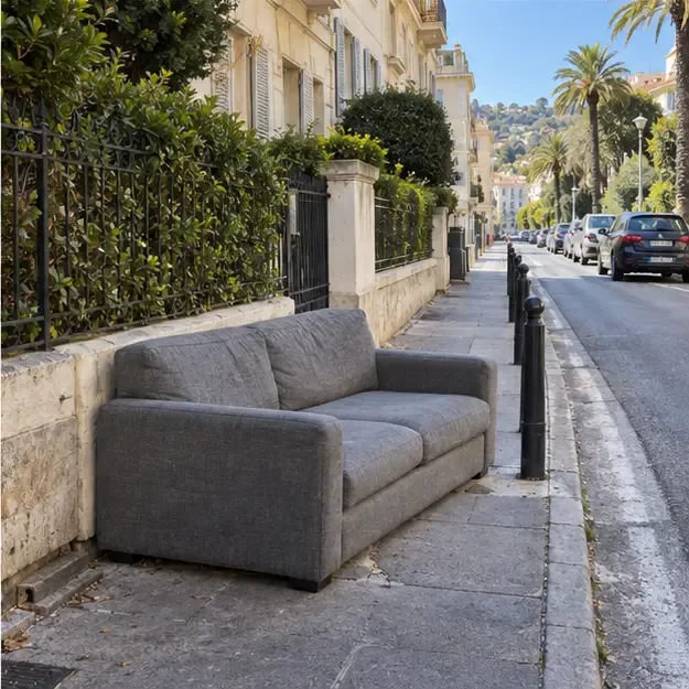 Un canapé est présenté sur un trottoir d’une rue résidentielle de Nice en laissant une bande de passage dégagée