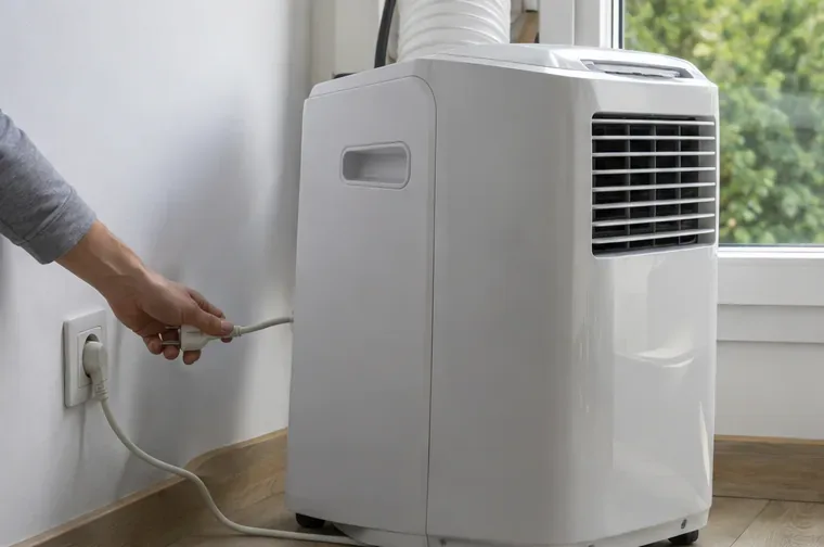 Main débranchant un climatiseur mobile blanc éteint près d’une prise murale