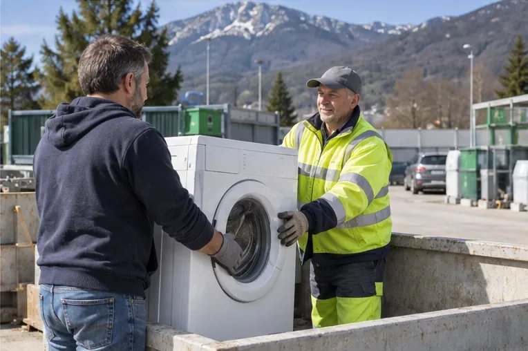 Habitant remettant un lave-linge à un agent en gilet haute visibilité dans une zone de collecte