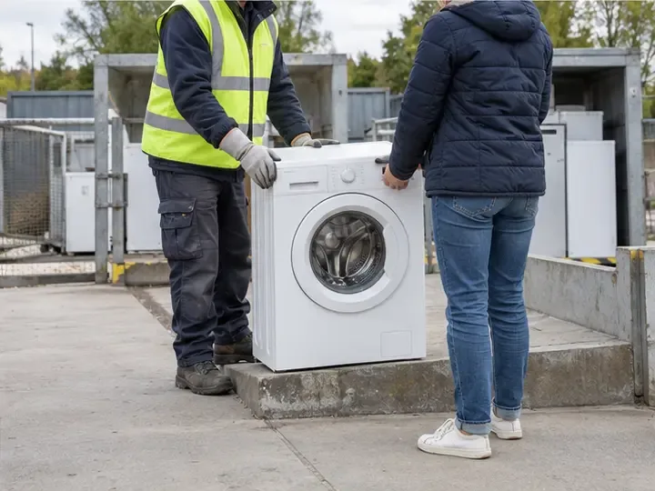 Agent en gilet haute visibilité et habitant déposant un lave-linge dans une zone de collecte du gros électroménager