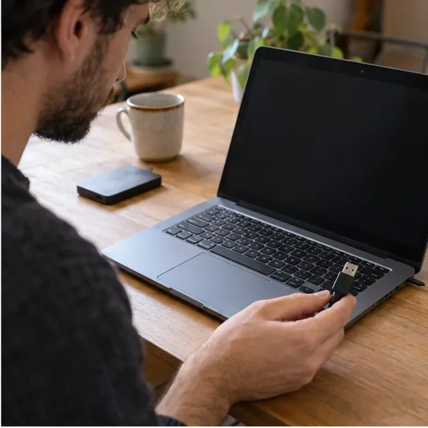 Ordinateur portable à écran éteint et support externe sur une table