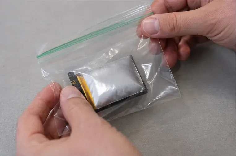 Une batterie lithium gonflée placée séparément dans un sac plastique transparent à fermeture zip