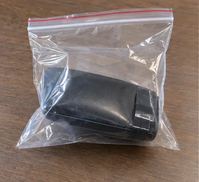 Batterie externe gonflée placée seule dans un sachet plastique transparent à fermeture zip