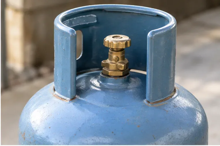 Gros plan sur le robinet fermé d’une bouteille de gaz protégée par sa collerette