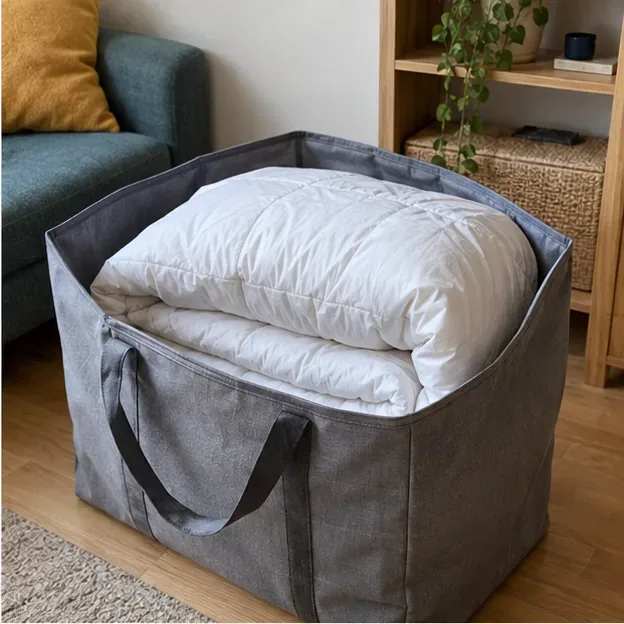 Une couette blanche propre et pliée dans un grand sac de transport en tissu avant un don ou une reprise
