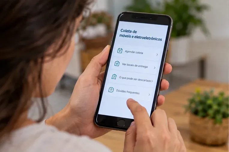 Pessoa usando um celular para consultar opções de coleta e locais de entrega de eletroeletrônicos