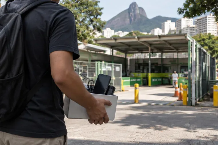 Pessoa levando celulares e pequenos eletrônicos para um ponto de coleta de resíduos eletrônicos