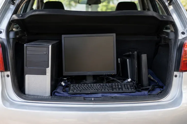 Porta-malas com gabinete de computador, monitor, teclado e outros equipamentos acomodados para transporte