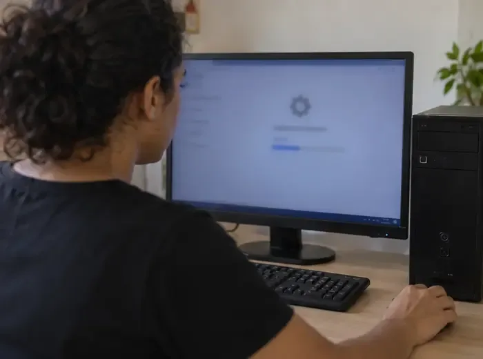 Pessoa iniciando a restauração de um computador de mesa com o conteúdo da tela desfocado