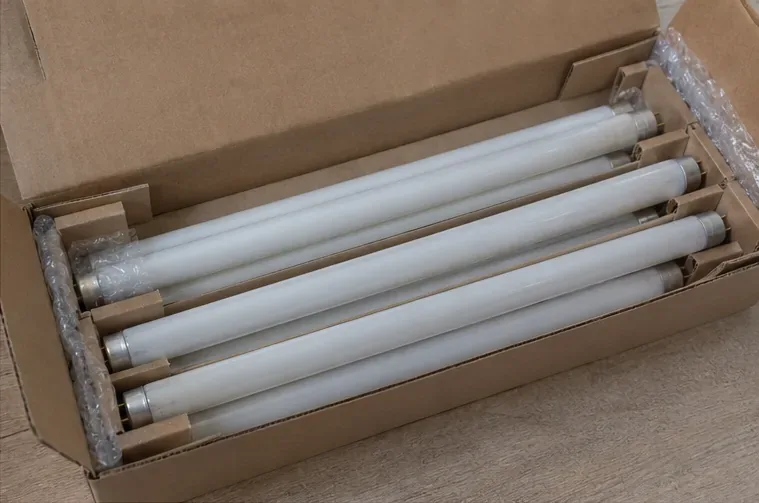 Lâmpadas fluorescentes tubulares inteiras acomodadas em uma caixa de papelão com divisórias para evitar choques entre os tubos