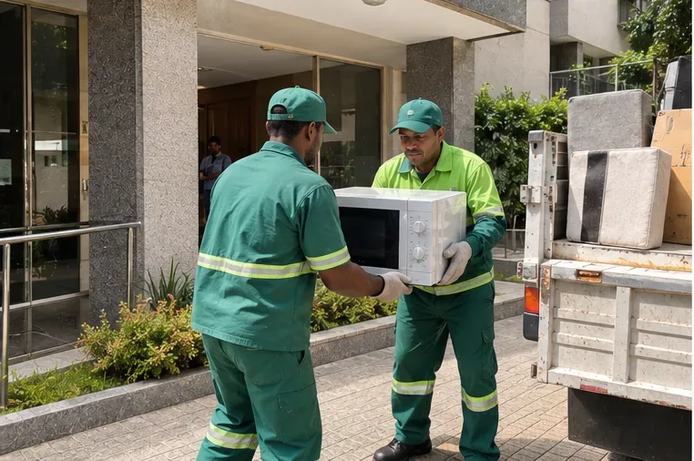 Trabalhadores de coleta carregando um micro-ondas inteiro para um veículo de serviço