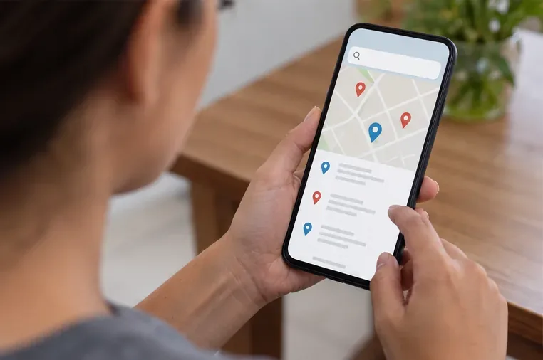 Pessoa consultando no celular um mapa com pontos de recebimento antes de levar o micro-ondas