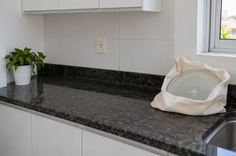 Bancada de cozinha vazia com o prato de vidro do micro-ondas protegido dentro de uma bolsa de tecido.