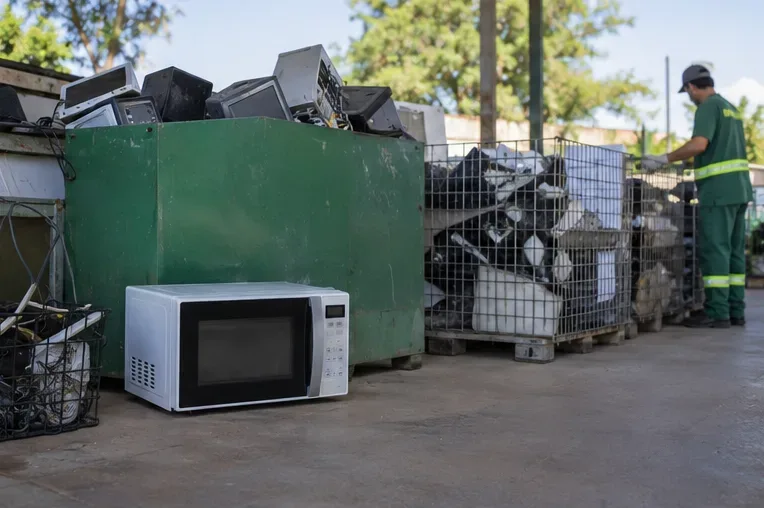 Micro-ondas separado junto a recipientes de reciclagem de equipamentos eletrônicos