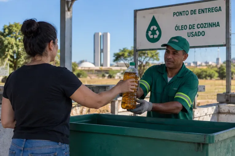 Mulher entregando uma garrafa fechada de óleo de cozinha usado a um trabalhador em um ponto de coleta.