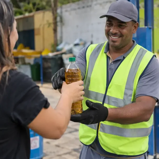 Trabalhador usando colete de segurança recebendo uma garrafa PET fechada de óleo de cozinha