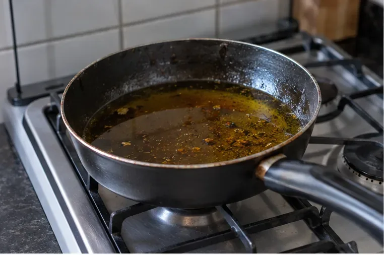 Frigideira com óleo de cozinha usado já fora do processo de fritura, aguardando esfriar antes do armazenamento