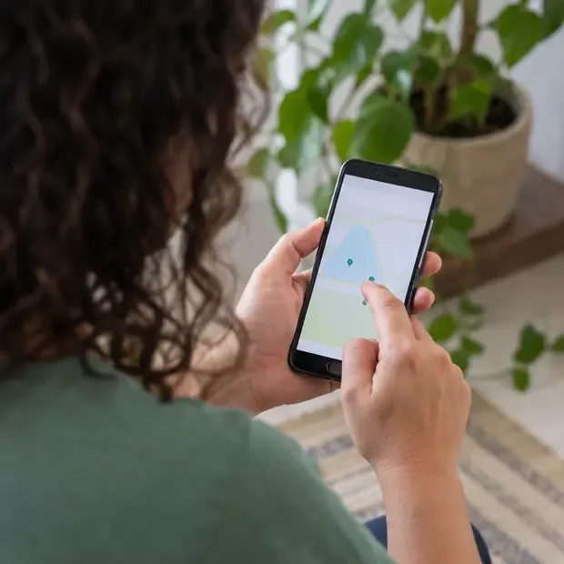 Pessoa consulta no celular um mapa com locais de recebimento de resíduos