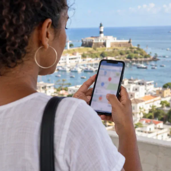 Pessoa consultando no celular um mapa de pontos de coleta em Salvador, com a tela desfocada