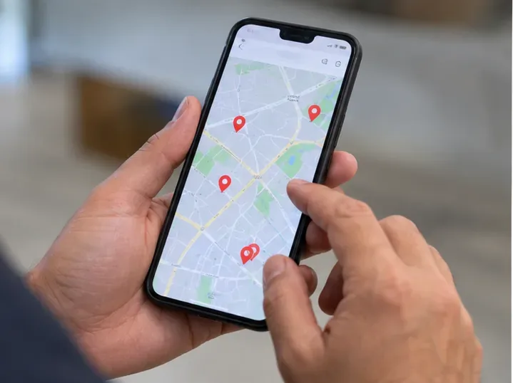 Pessoa consultando em um smartphone um mapa com marcadores de pontos de coleta para escolher onde levar um power bank