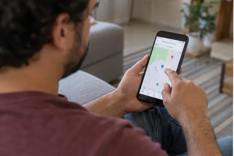 Pessoa consultando no celular um mapa para localizar um ponto de recebimento de eletrônicos