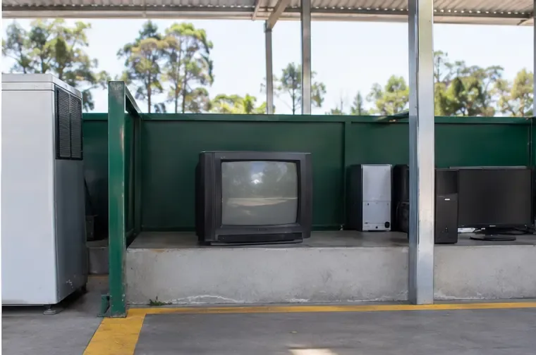 Área coberta e organizada com televisões e outros equipamentos eletrônicos separados dos demais resíduos
