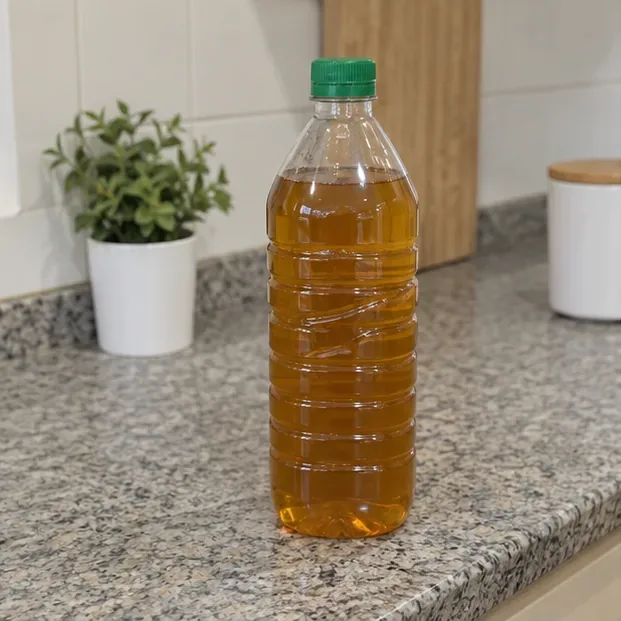 Botella de plástico cerrada y llena de aceite de cocina usado lista para llevar a un punto de recogida