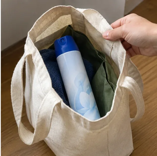 Un bote de aerosol intacto colocado dentro de una bolsa de tela para transportarlo sin golpearlo ni perforarlo